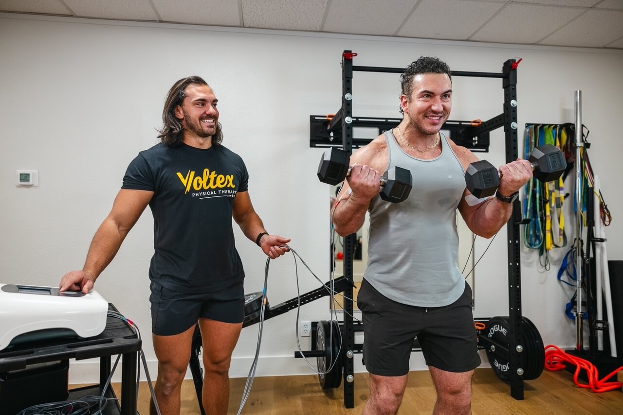 Dr. Hector Tricas coaching a client through a strength session at Voltex Physical Therapy in Austin, TX